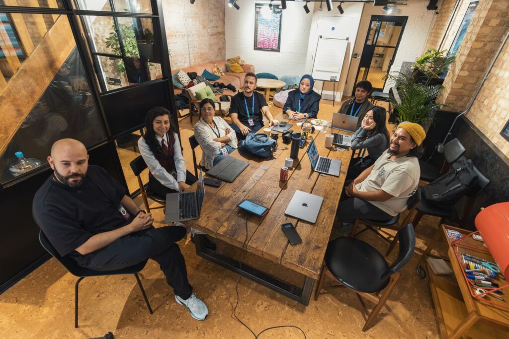 Diverse IT team collaborating around laptops while closing the AI skills gap