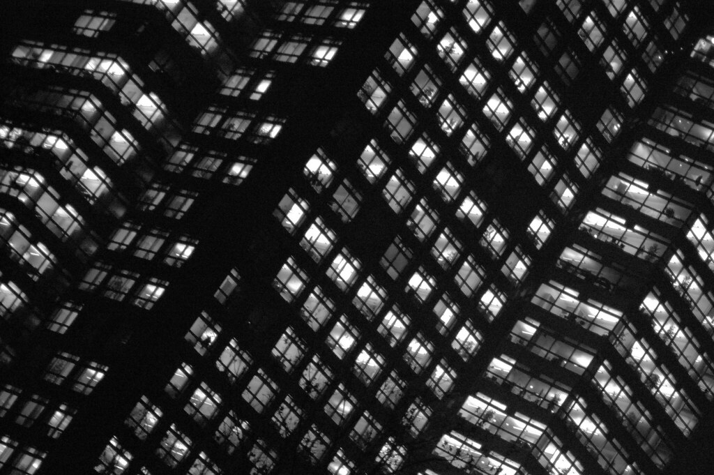 Engineer working late at a lit desk at night, the pattern follow-the-sun support is designed to replace