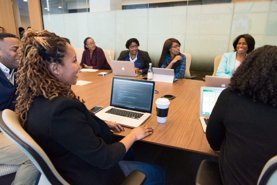 IT contractor churn handover: an engineering team reviewing client documentation together in a meeting room
