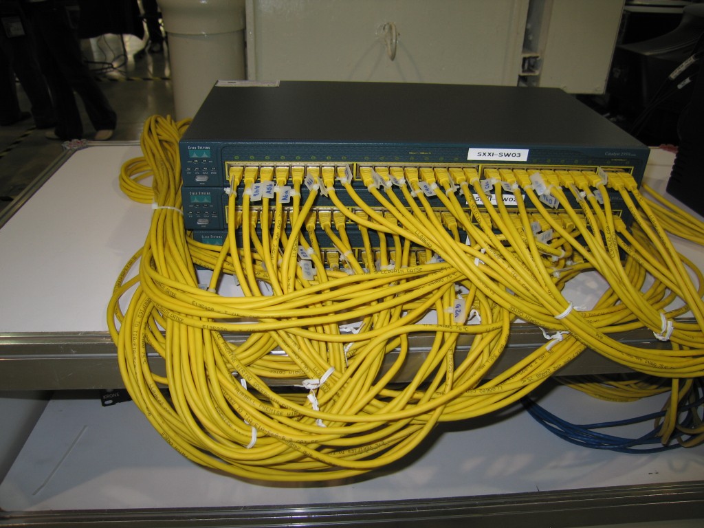 Network device firmware update in progress on a rack-mounted switch and patch cables
