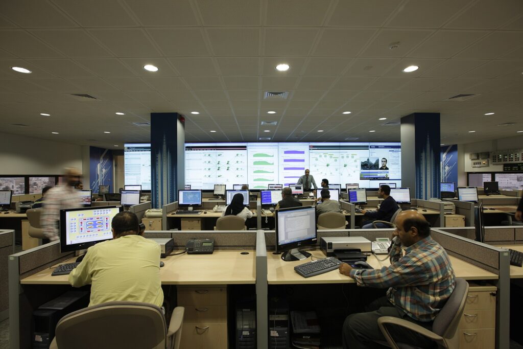 NOC outsourcing team monitoring network dashboards in a network operations centre