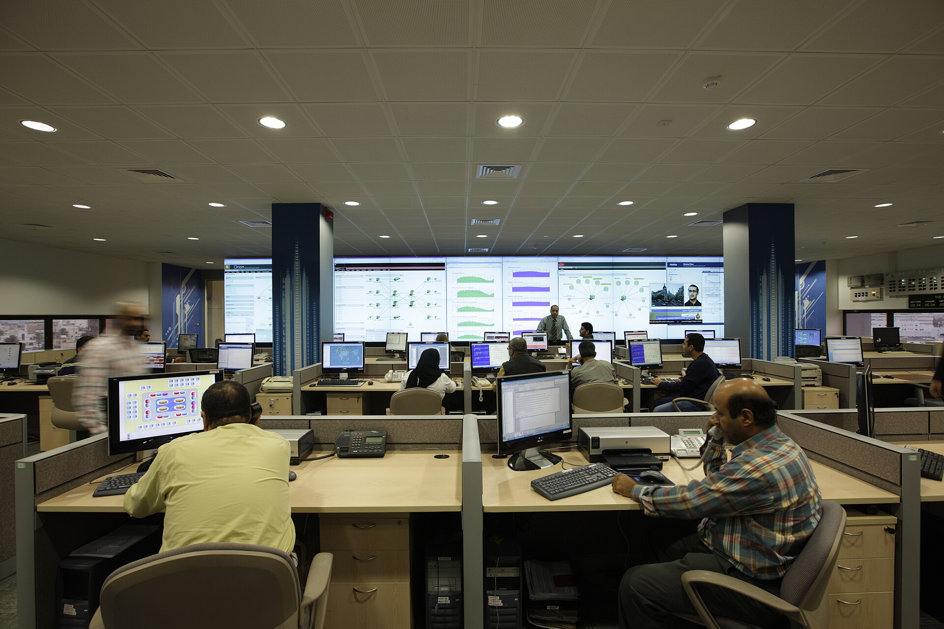 NOC outsourcing team monitoring network dashboards in a network operations centre