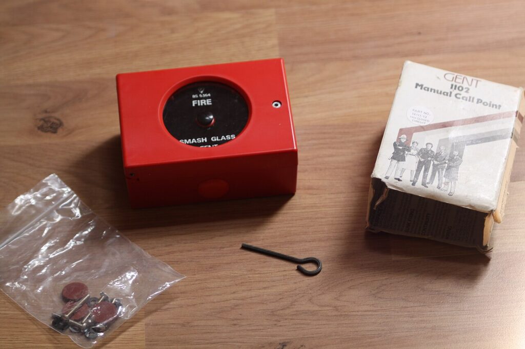 Break-glass accounts illustrated by a red manual break-glass fire alarm call point mounted on a wall