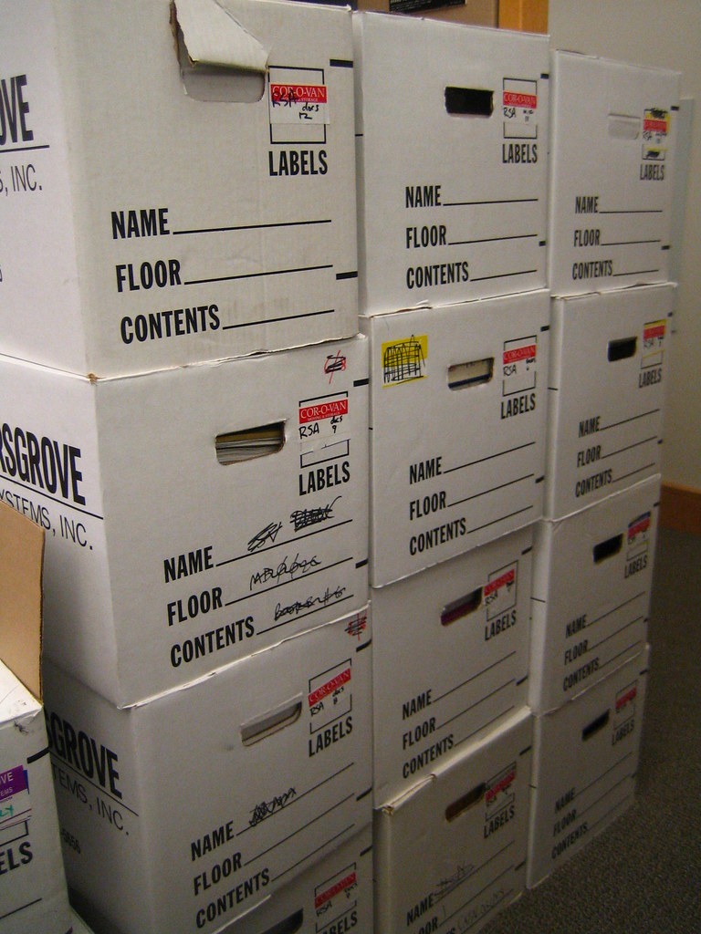 Packed cardboard boxes in an emptied office, illustrating client offboarding for an MSP