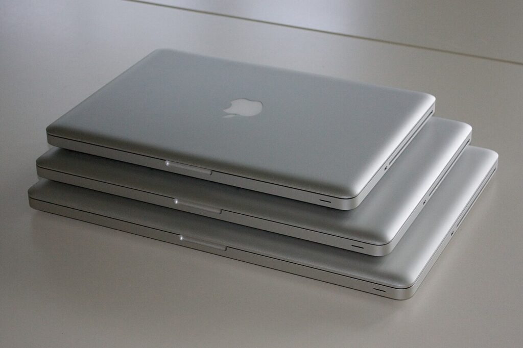 Stacked laptops waiting for IT asset recovery, wipe and redeployment